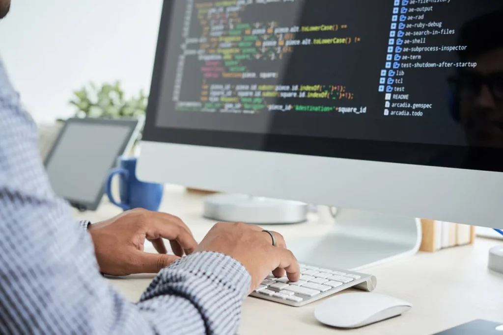 Software developer coding on desktop computer
