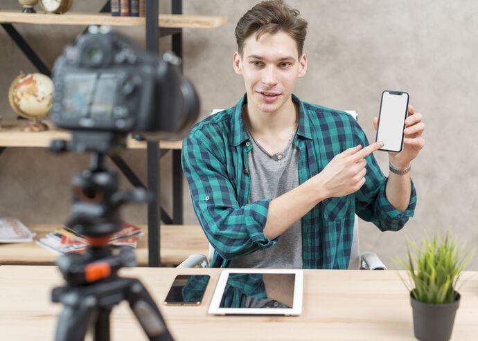 Tech vlogger showcasing a smartphone while recording a promotional video